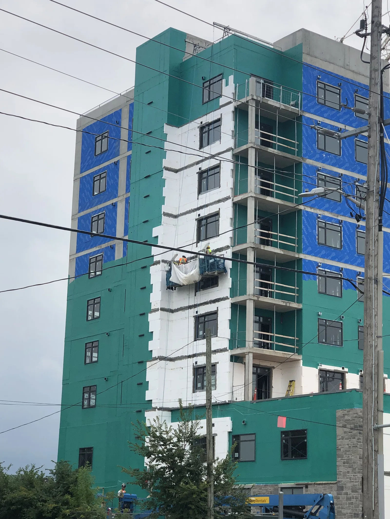 Residential high-rise wrapped in exterior sheathing during construction