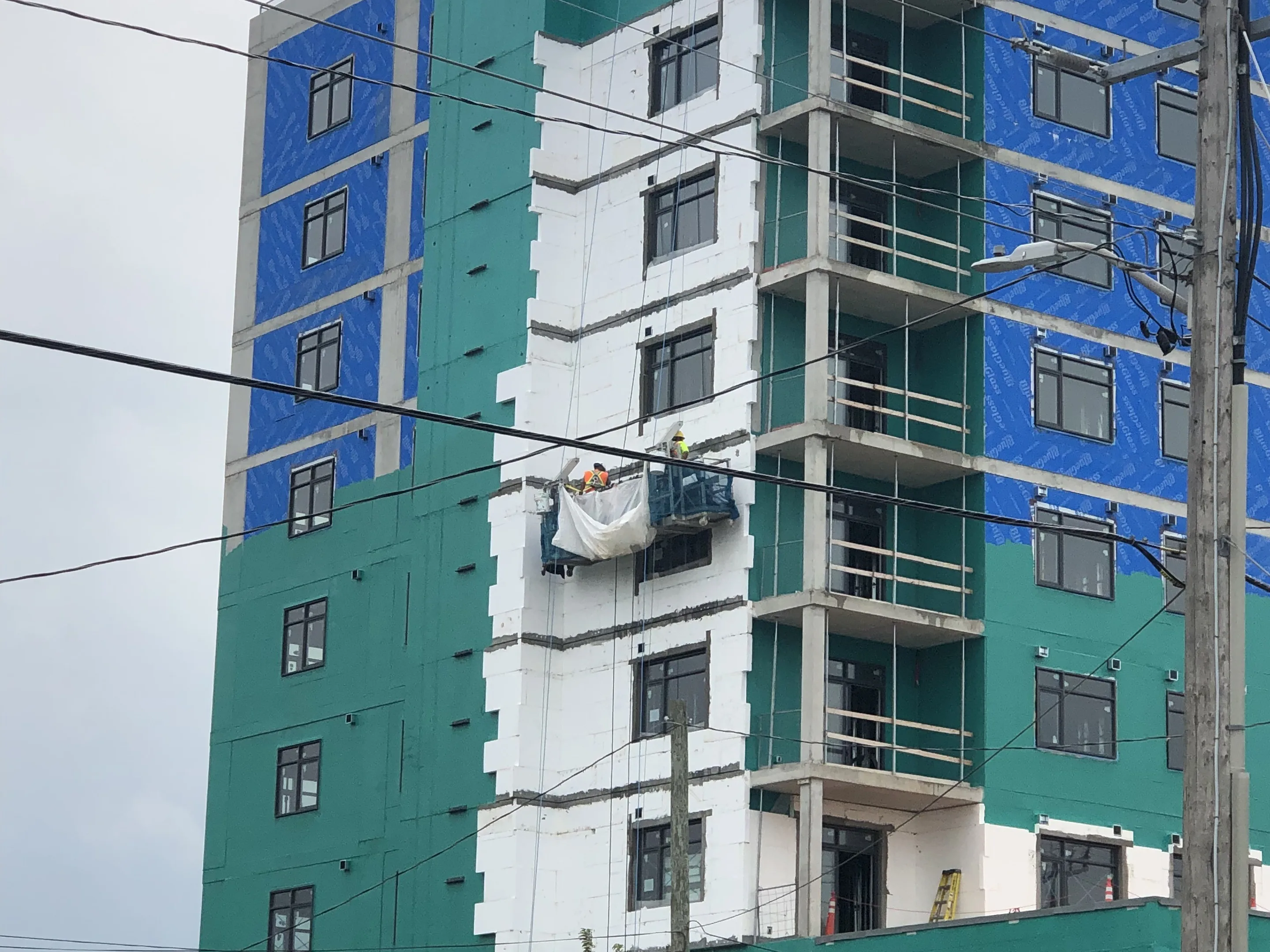 Residential high-rise wrapped in exterior sheathing during construction